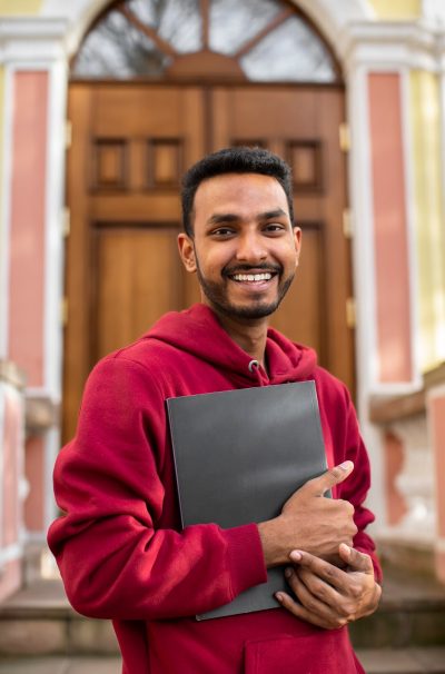 front-view-smiley-man-holding-book_23-2149915900